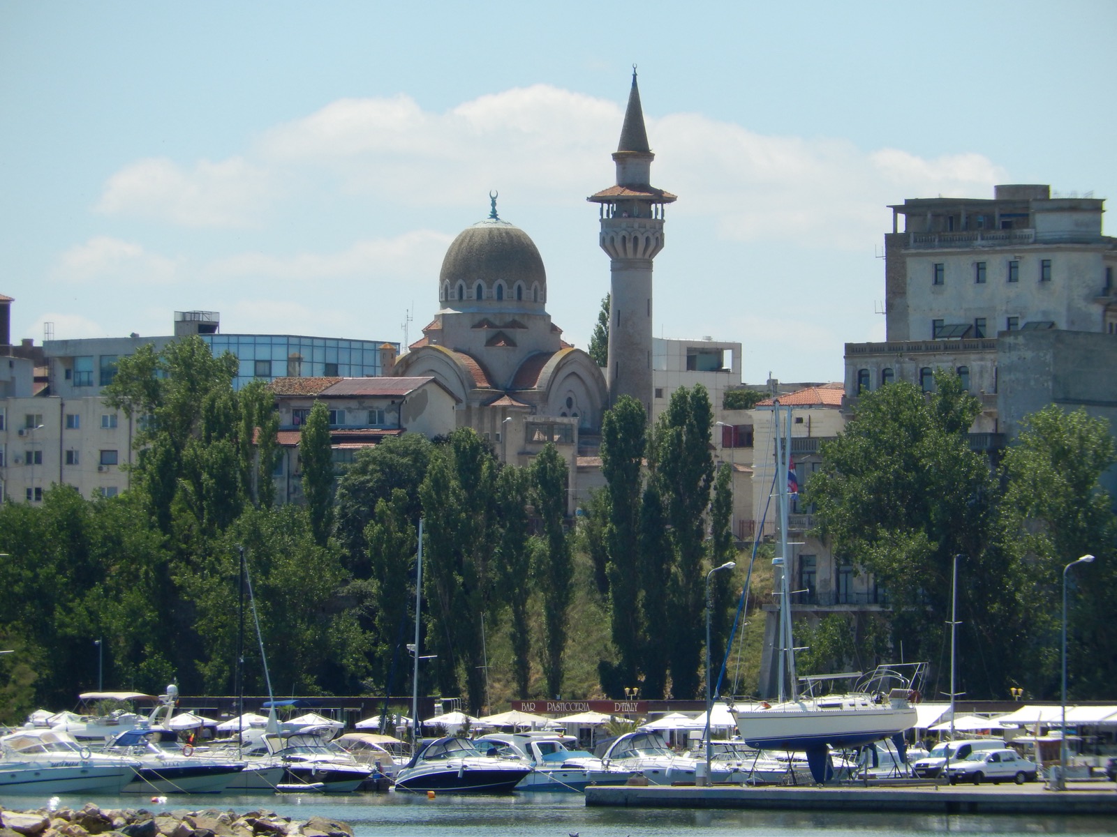 Kuppel und Minarett der Moschee über den Bäumen der Halbinsel, gesehen vom Jachthafen mit seinen Booten