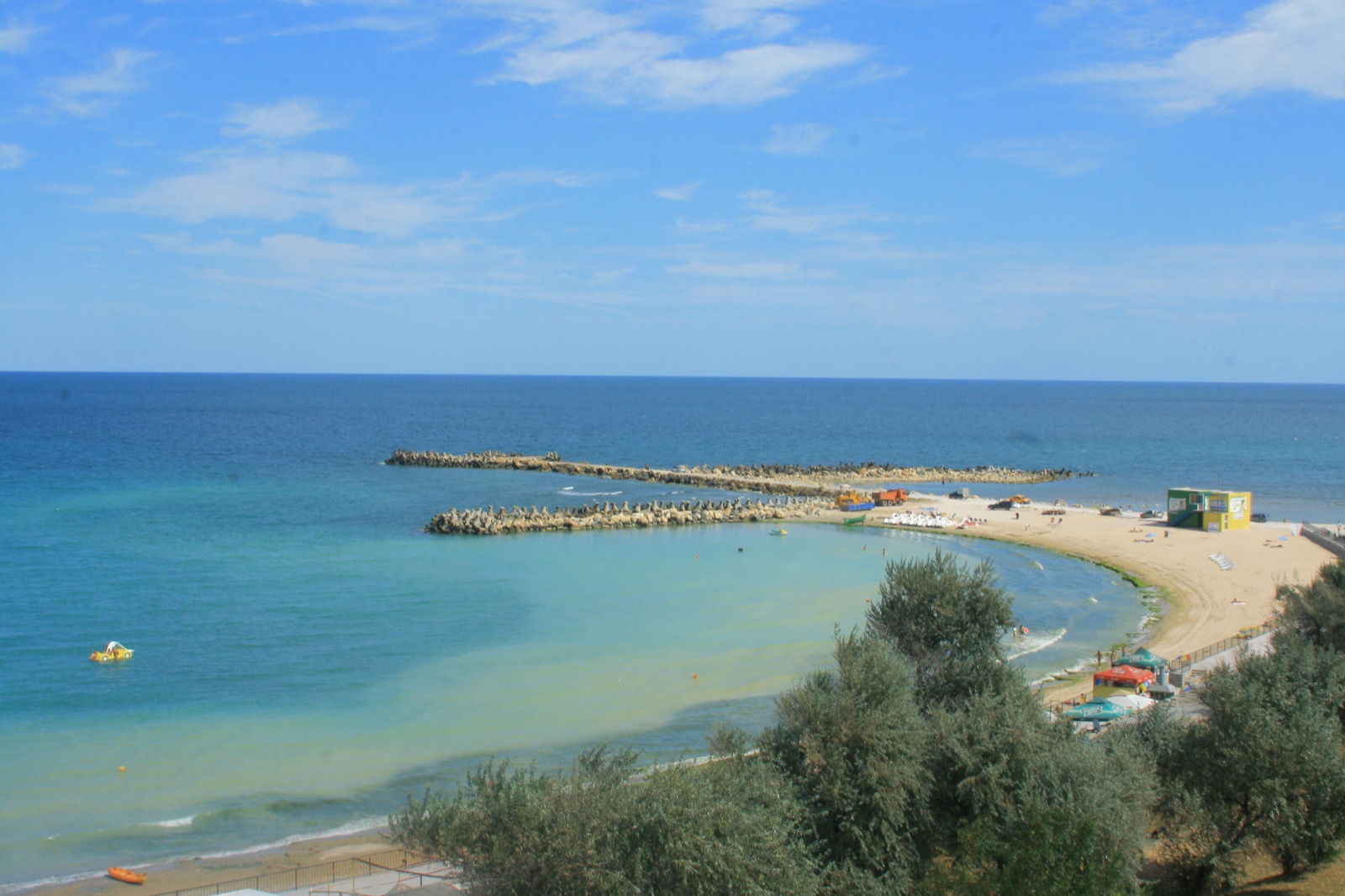 The Eforie Sud shore seen from the cliff top, with the curving beach, the stone groynes and turquoise water