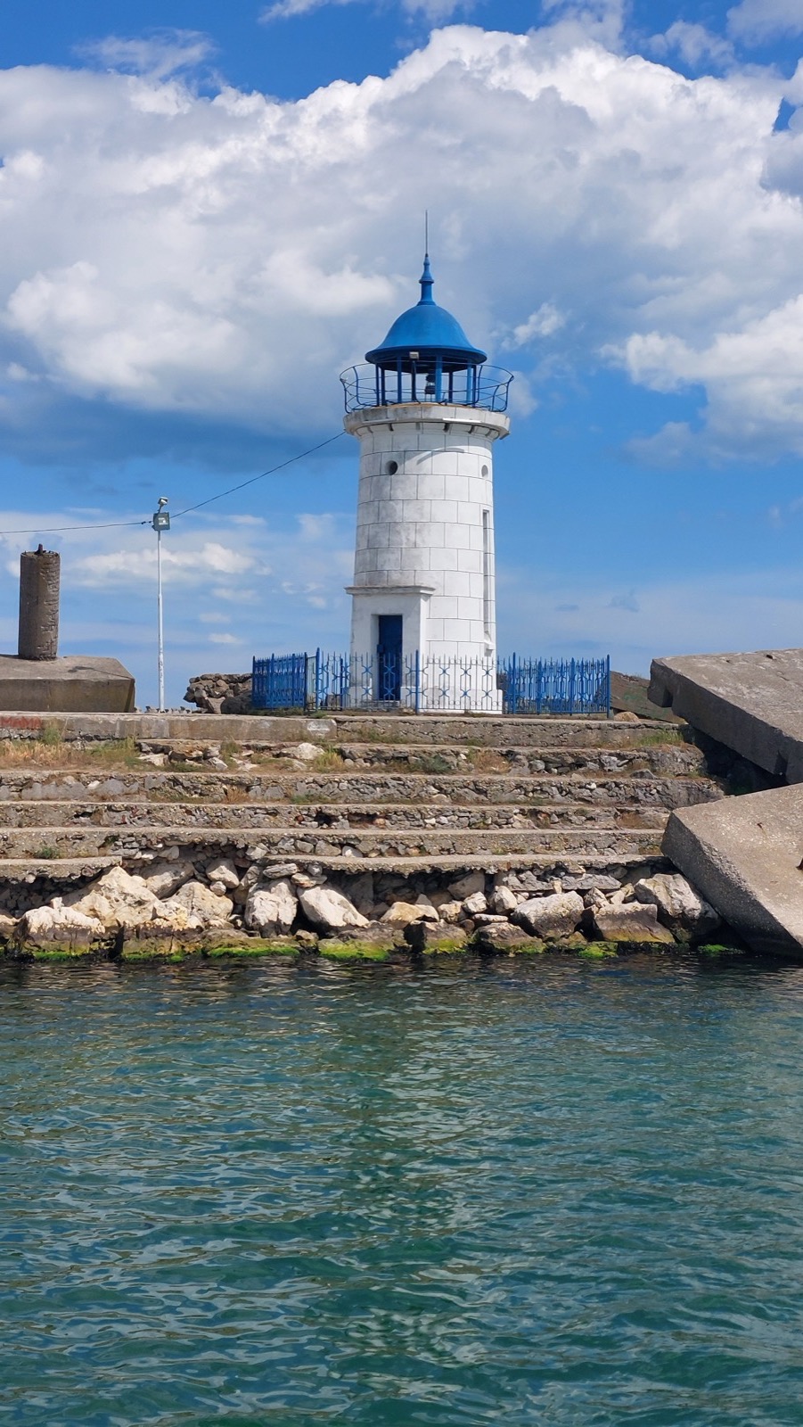 Farul genovez din Mangalia, alb cu cupolă albastră, pe digul de lângă portul turistic